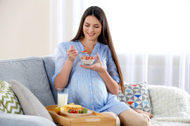 kobieta w ciąży jedząca śniadanie