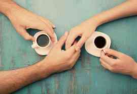 Para dłoni i filiżanki kawy