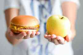 hamburger i jabłko na dłoni