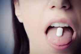 kobieta i tabletka na języku