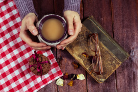 herbata Chai dłonie ciastka okólary i książka